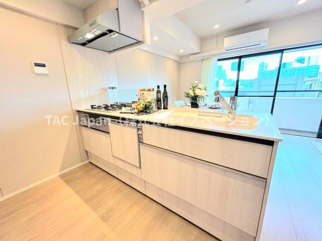 サンヴェール門前仲町のキッチン|美しさと機能性に定評のある対面キッチンを採用しました。高級感ある人造大理石カウンター、排水一体型人造大理石シンク、３口コンロ、浄水器内蔵シャワー混合栓、食器洗浄機を完備。