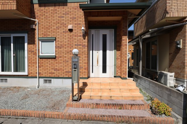 中古戸建　太子町太田のエントランス|白い玄関ドアが茶系の壁面に映えますね！
