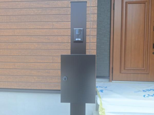 ふじが丘南3丁目1期1号棟の玄関|玄関にはモダンなデザインのポストとインターホンが設置されています。シンプルで洗練された外観が印象的です。段差の少ないアプローチで出入りしやすい仕様です。玄関ドアは木目調の落ち着いた雰囲気です。
