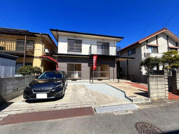 松山市空港通　４LDK　再生住宅の外観|2026年4月に屋根・外装をリフォーム。白く輝く外壁が周囲の緑に映える。駐車2台可能なゆとりが、心の余裕にも繋がる一軒家がここに。