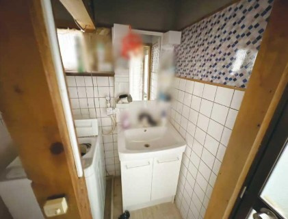 【解体更地渡し相談可】高知市佐々木町　中古一戸建ての洗面所|木の温もりを感じるアクセント。洗濯機置場もゆとりある配置