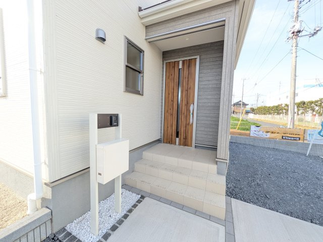 小美玉市上玉里　第2　新築戸建て　1号棟の玄関|お洒落な玄関ドアと洗練された外壁デザイン。家の顔にふさわしい上質な佇まいで、ご家族やお客様を迎えます。