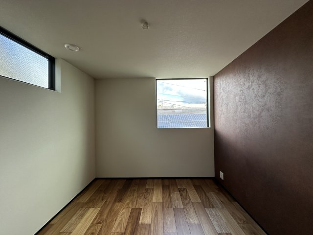 北名次町高性能住宅の洋室|温もりのあるブラウンのアクセントクロスが、落ち着きと重厚感を感じさせる空間。シックで上品な雰囲気が、