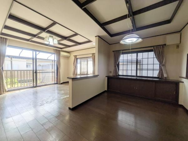 新明治5丁目　戸建の居間・リビング|リビングは広々とした空間が広がり落ち着いた色合いのフローリングが特徴です。天井のデザインがアクセントとなり上質な雰囲気を演出しています。窓からの自然光が室内を明るく照らし開放感を感じられます。