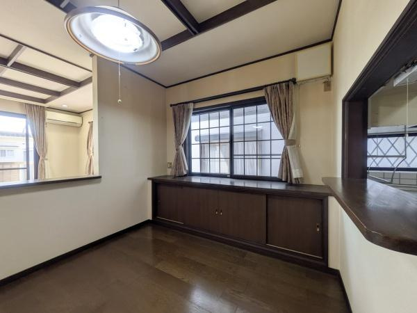 新明治5丁目　戸建の居間・リビング|ダイニングにも大きな窓があり明るい光が差し込みます。落ち着いたダークブラウンの床が空間を引き締めます。