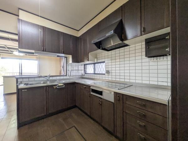 新明治5丁目　戸建のキッチン|落ち着いた色合いのキッチンで空間に統一感があります。収納が豊富で使い勝手の良い配置です。L字型のレイアウトで作業がしやすい造りとなっています。窓があり採光もしっかり確保されています。