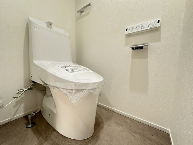 恒陽マンションのトイレ|タオルフォルダー付き！ストーン調の床と白い壁の相性は◎