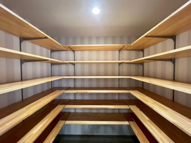 高岡町 平屋の収納|２．５帖の大容量パントリーは可能棚ですので、使い方に合わせてカスタマイズできます。壁は遊び心のあるナチュラル系ストライプ。