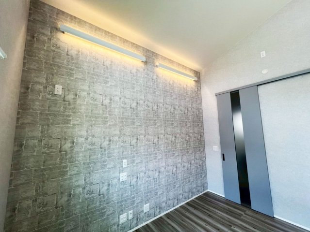 高岡町 平屋の居間・リビング|リビングの天井高は３．２ｍ～５．１ｍ。入口引戸もハイドア（Ｈ＝２．４２０ｍｍ）を採用し、ＬＤＫの解放感を際立たせています。壁掛けテレビに対応可能な隠し配管処理と下地処理を施しています。