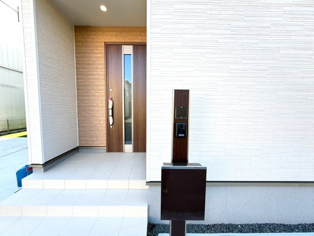 静岡市葵区田町２丁目142番　全２棟の玄関|玄関まわりにはポストとインターホンをすっきり配置。木目調で統一されたデザインが、外観に落ち着いたアクセントを添えています。