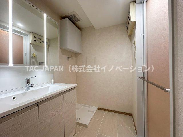 朝日サテライト上野の洗面所|大型の洗濯機を置いても余裕が感じられる脱衣スペースにはお洒落な洗面ユニットを制作。着替えやタオル、洗剤の買い置きなどリネン庫の使い方はお客様しだい。
