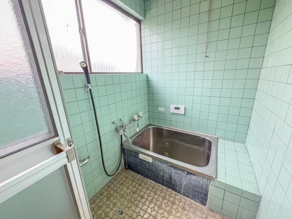 松岡　戸建ての浴室|バスルームは広々とした空間でレトロなタイルが特徴です。窓があり自然な明るさが差し込みます。浴槽周りのスペースもゆったりと設けられています。換気しやすい構造で清潔感を保ちやすいです。