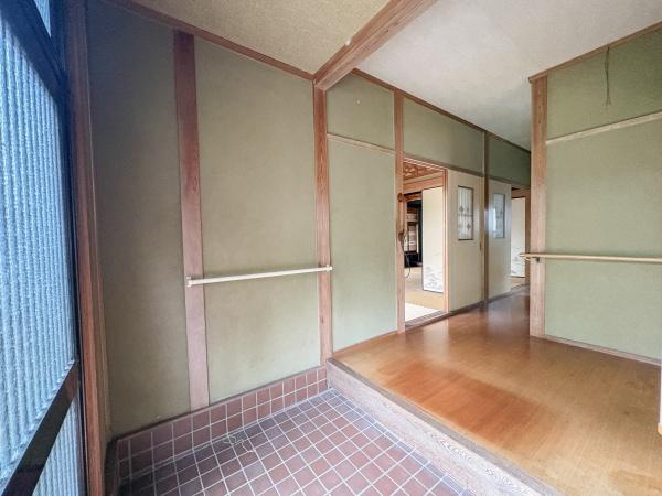 松岡　戸建ての玄関|広々とした玄関スペースが印象的です。木の質感と和風のデザインが落ち着いた雰囲気を演出します。段差部分には手すりが設置されており使い勝手が良いです。室内へと続く動線もスムーズです。