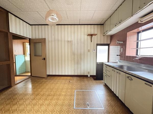 松岡　戸建てのキッチン|広々としたキッチンスペースでゆとりを感じられます。窓が大きく明るい光が差し込むのが印象的です。収納が充実しており整理整頓しやすいです。床や壁紙のデザインがレトロな雰囲気を演出しています。