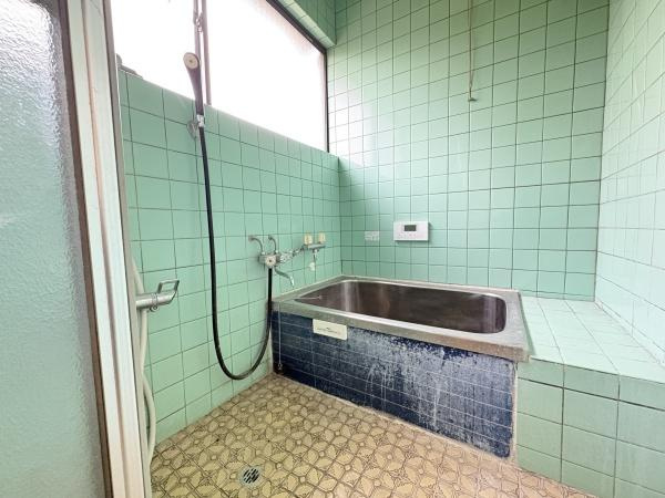 松岡　戸建ての浴室|大きな窓があり明るい光が差し込むバスルームです。広々とした浴槽でゆったりとした時間を過ごすことができます。タイル張りの内装が清潔感を感じさせます。床や壁のデザインが特徴的で個性的な空間です。
