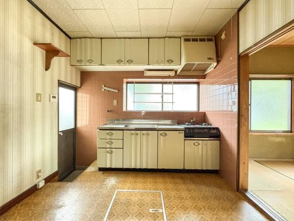 松岡　戸建てのキッチン|大きな窓から自然光が差し込むキッチンです。吊戸棚や収納スペースも豊富に備えています。隣接する和室との動線が便利です。換気扇やガスコンロ付きで日々の料理をサポートします。