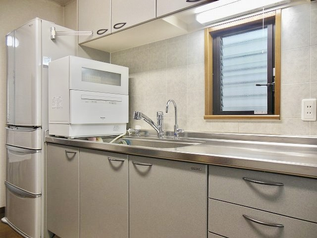 住吉山手２丁目戸建のキッチン|横長で広めのシンク、3口コンロです。
玄関、リビング側どちらからもキッチンに通じておりますので、
炊事をしながら洗濯できるなど家事動線が短くて効率的ではないでしょうか。