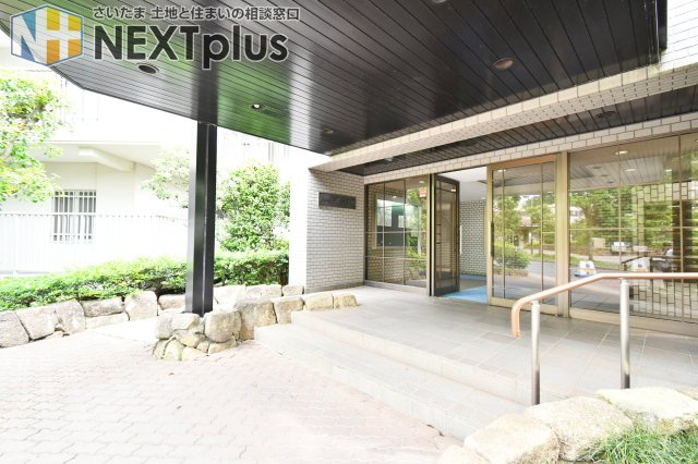 パーク上尾弐番館のエントランス|ゆとりあるアプローチが住まう人を優雅に迎えるエントランスです。上尾駅徒歩7分の好立地にありながら、植栽の豊かな緑が駅前の喧騒を忘れさせ、毎日の帰宅時に安らぎを与えてくれます。