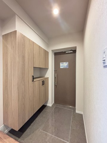 リノベーションで美しく生まれ変わった玄関。木目調の建具が温かみのある空間を演出します。