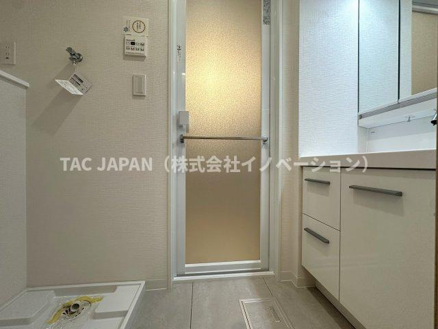 グランヴェルジェ西台の洗面所|大型の洗濯機を置いても余裕が感じられる脱衣スペースにはお洒落な洗面ユニットを制作。着替えやタオル、洗剤の買い置きなどリネン庫の使い方はお客様しだい。