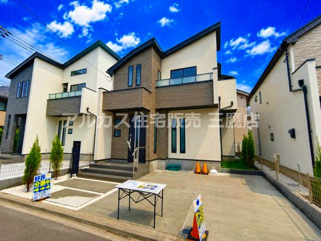 三鷹市北野4丁目 京王線 仙川駅 新築戸建の前面道路含む現地写真|青空に映えるスタイリッシュな外観。カースペースや整えられた植栽が魅力的です。