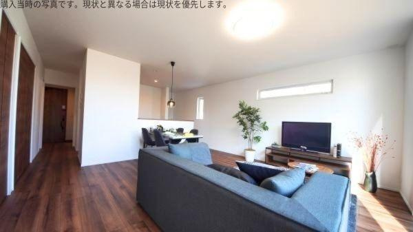 大字皆春　戸建ての居間・リビング|開放感のあるリビングが印象的です。大きな窓から光が差し込み明るい空間となっています。すっきりとしたインテリアで心地よく過ごせます。ウッド調の床が落ち着いた雰囲気を演出します。