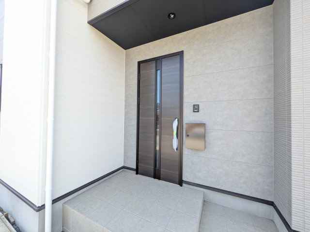 ひたちなか市高場　6期　新築戸建　1号棟の玄関|お洒落な玄関ドアと洗練された外壁デザイン。家の顔にふさわしい上質な佇まいで、ご家族やお客様を迎えます。