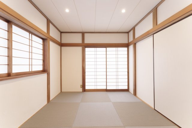 狭山市水野中古戸建2180万円【武蔵藤沢駅徒歩８分】の和室|伝統的な柱の見せ方と、現代的なグレーの縁なし畳（琉球畳）が融合した和室。色味を抑えたモノトーンな構成が、和の空間に静かなモダンさを与えています