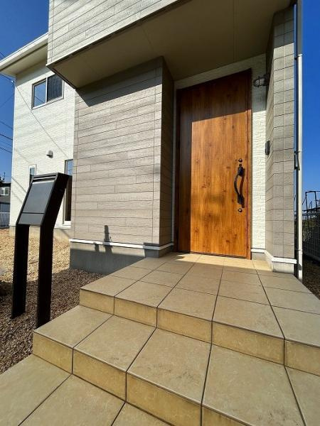 新居浜市中村1丁目　中古戸建の玄関|収納力のあるシューズボックスを備えた、魅力あふれる玄関。TVモニター付インターホンで来客をしっかり確認できるので、お子様の留守番時も安心。いつもスッキリ整った玄関が、家族やゲストを優しく迎える。