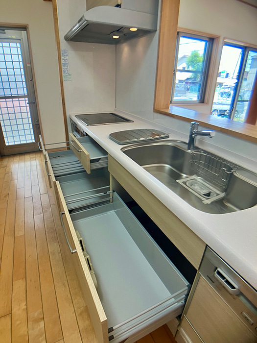 新須賀町3丁目　５SLDK　再生住宅のキッチン|使いやすく汚れにくいシステムキッチン。3口コンロで同時調理ができるから、忙しい夕方も手際よく料理を仕上げて、家族との会話をゆっくり楽しむ姿が浮かぶ。