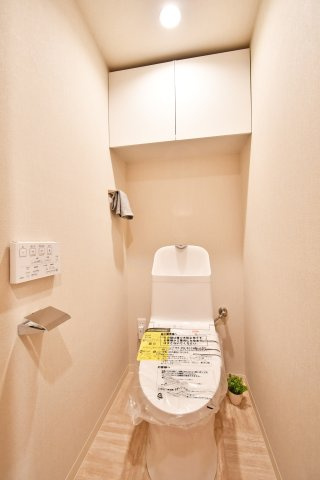 エクレール第四岩槻のトイレ|清潔感あふれる温水洗浄便座付きトイレへ新規交換済み。上部には便利な吊戸棚を備え、生活感を隠してスッキリ収納できます。白を基調とした落ち着いた空間で、日々の暮らしに安らぎをプラスします。