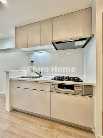 新大橋永谷マンションのキッチン|【システムキッチン】ワイドで収納豊富な使い勝手の良いシステムキッチンには、伸縮タイプのキッチン水栓、三ツ口コンロ・魚焼きグリルなどの便利な設備が標準完備されています。