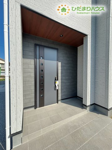 熊谷市拾六間　第6　新築一戸建て　リーブルガーデン　01の玄関|アクセント壁がおしゃれな、開放感のある玄関ポーチです! 木目調のドアが、温かみのある雰囲気を演出してくれます♪ 広いスペースがあるので、ベビーカーや自転車などを置くこともできて便利ですよ♪
