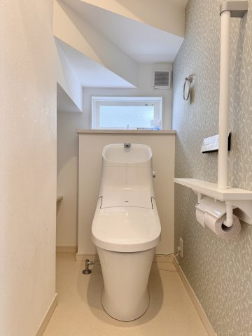 浜名区中瀬のトイレ|階段下を有効活用したトイレにです。手すりや窓もついております。
