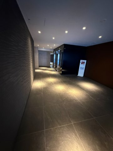 パレステージ大島のロビー|間接照明がやわらかく足元を照らす、落ち着きある共用廊下。石調タイルとダークトーンの壁面が上質な空間を