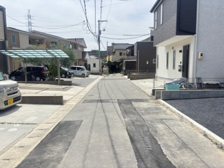 【前面道路含む現地写真】 | 佐伯区八幡1丁目（全6棟）No5 | 前面道路はアスファルト舗装が施され、落ち着いた住宅街の雰囲気が漂います。周辺には新しい戸建も並び、すっきりとした景観が保たれています。お車での出入りもスムーズに行える道幅が確保されています。