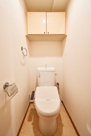グリーンミユキ吉野町のトイレ|白を基調とした清潔感のあるトイレには、便利な温水洗浄便座付き。上部には扉付きの吊戸棚があり、トイレットペーパーや掃除用品をスッキリ収納可能。リフォーム済みで非常に綺麗です。