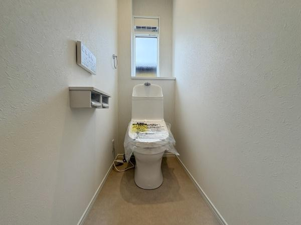 P-TELAS南津留のトイレ|シンプルで清潔感のあるトイレ空間です。窓が設けられており明るさも確保されています。壁面の質感も落ち着いた印象です。ペーパーホルダーや操作パネルも使いやすい位置に配置されています。