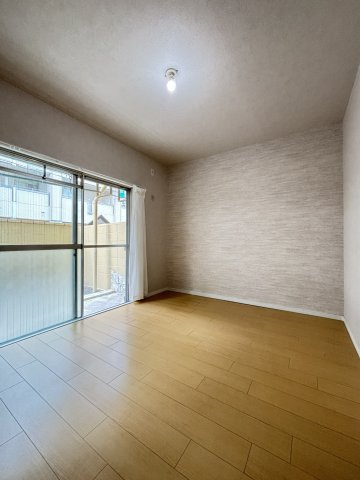 甲南第10兵庫コーポラスの洋室|専用庭に面した大きな窓から明るい光が差し込む、落ち着いたアクセントクロスが印象的な約5.6帖の洋室です。