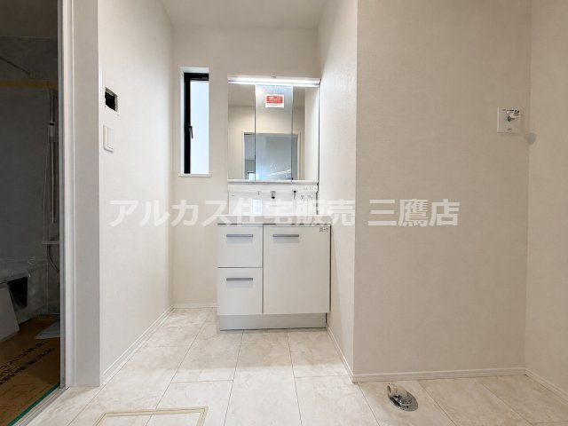 西武新宿線 花小金井駅 15分 新築戸建 小平市鈴木町1丁目の独立洗面台|三面鏡付きの洗面化粧台と洗濯機置場。脱衣スペースとしてもゆとりある広さが確保されています。