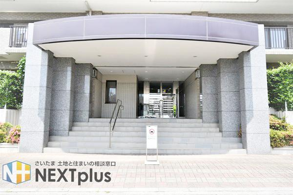 新大宮パークホームズのエントランス|重厚感漂う石張りの柱と、大きなキャノピーが穏やかな住環境を象徴するエントランス。日勤管理による美しい共用部が、住まう人を心地よく迎え入れます。日進駅徒歩10分の利便性と共に、安心の暮らしを支えます。