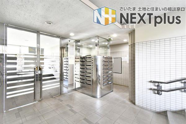 新大宮パークホームズの設備|明るく開放的なエントランス内の郵便受けコーナー。手すり付きのスロープが設置されたバリアフリー設計で、ご高齢の方やベビーカー利用者も安心です。オートロックと連動し、日々の動線もスムーズで快適な造りです。