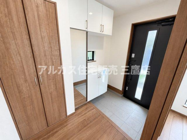 西武新宿線 花小金井駅 15分 新築戸建 小平市鈴木町1丁目の玄関|身だしなみを整える全身鏡と収納豊富なシューズボックスを配置した、木目調が心地よい玄関ホール。