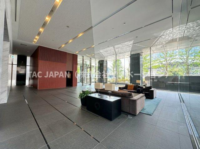 コートレジデントタワーのエントランス|ホテルライクな開放感と上質感が漂うエントランスホール。ガラス越しに緑を望むラウンジには洗練されたソファが配され、住まう方を毎日上質な気分で迎え入れる、まさに邸宅にふさわしい風格の空間です。
