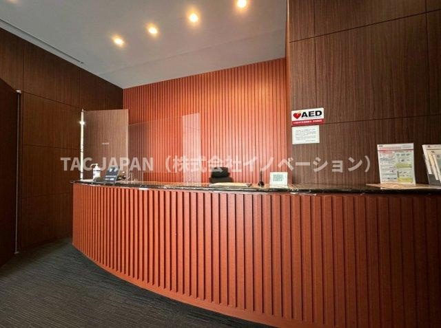 コートレジデントタワーのエントランス|温かみある木目に包まれたコンシェルジュカウンター。経験豊富なスタッフが住まう方一人ひとりに寄り添い、各種お問い合わせや生活サポートにきめ細やかに対応する、邸宅にふさわしいおもてなしの拠点です。