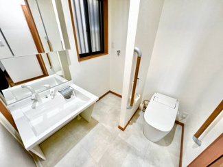 【洗面所】 | 陶器北　中古戸建 | 洗面室はトイレとつながった設計で高齢者にもやさしい広い空間になっています。手すり付きで安心ですね。