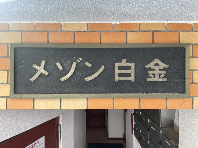 【現況写真】 | メゾン白金 | エントランスに掲げられた、マンション名を示す館銘板。さほど激しく主張はしませんが、しっかりと掲示されています。～即日のご見学可能～　お問合せはお気軽にどうぞ。
