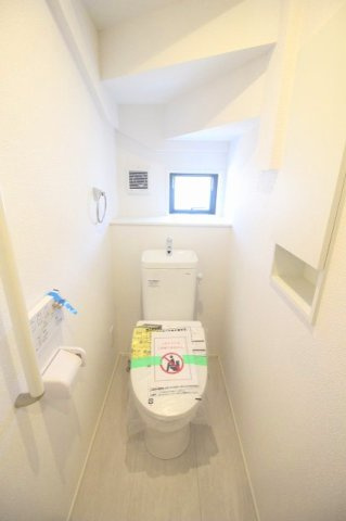 小山市駅南町5丁目　4期のトイレ|立ち座りをサポートする手すりと収納棚を備えた1階トイレ。窓があり、自然光を取り込みながら換気もできます。
