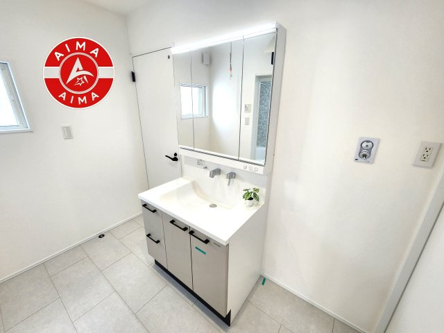 福津市有弥の里2丁目第1-3棟（2号棟）の独立洗面台|毎日使うものだから清潔な空間を保ちたい水回り。洗面にはそんな願いを解消させてくれる収納アイデアが満載です。三面鏡の裏側にはキャビネットが現れ小物から背の高い物まで収納できます。