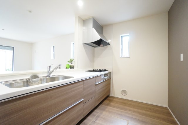 リーブルガーデン半田市北二ツ坂町2丁目第2　1号棟のキッチン|木目調のナチュラルなカラーリングが落ち着いた雰囲気の機能性の高いシステムキッチン。対面式のカウンター付きキッチンは自然と家族とのコミュニケーションが増えます♪